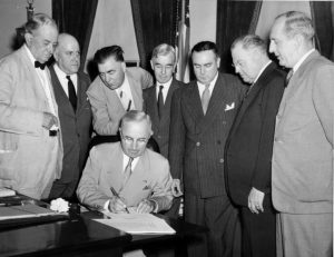 El presidente Harry S. Truman firmando el Acta de la Energía Atómica de 1946 que establecía la Comisión de Energía Atómica de los Estados Unidos.